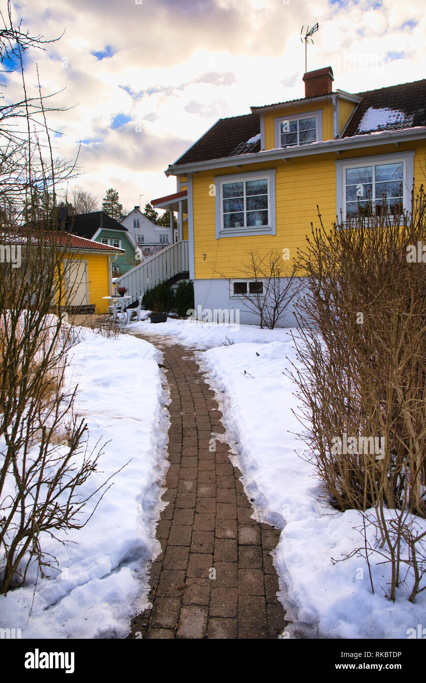 Footpath through snow to yellow painted house, Upplands Vasby, Stockholm, Sweden, Scandinavia Stock Photo