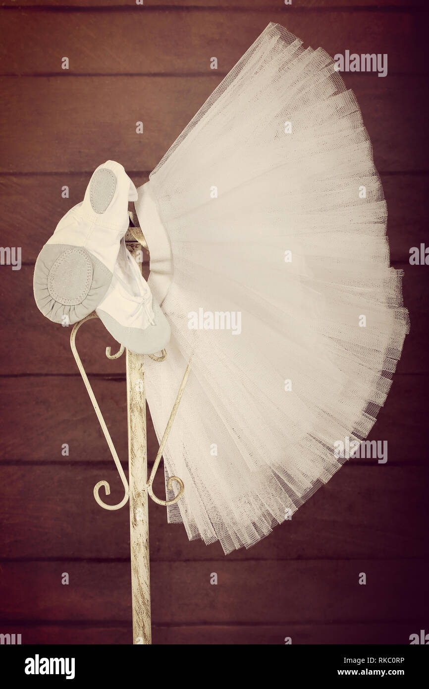 Pointes female ballet shoes with skirt tutu hanging on the stand, close up vintage view Stock Photo