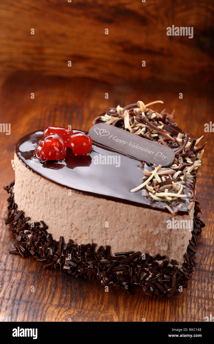 Sweet cake in the shape of a heart with the words Happy Valentines Day and empty space for text Stock Photo