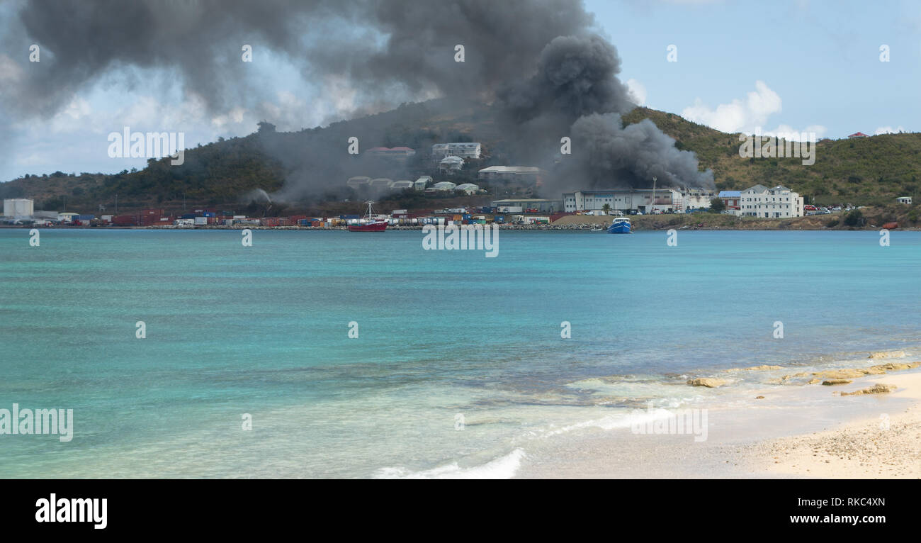 MARIGOT, ST. MAARTEN - February 6, 2019: Frigodom warehouse in the Galisbay Port, Marigot, St. Maarten was destroyed by fire despite efforts from both Stock Photo