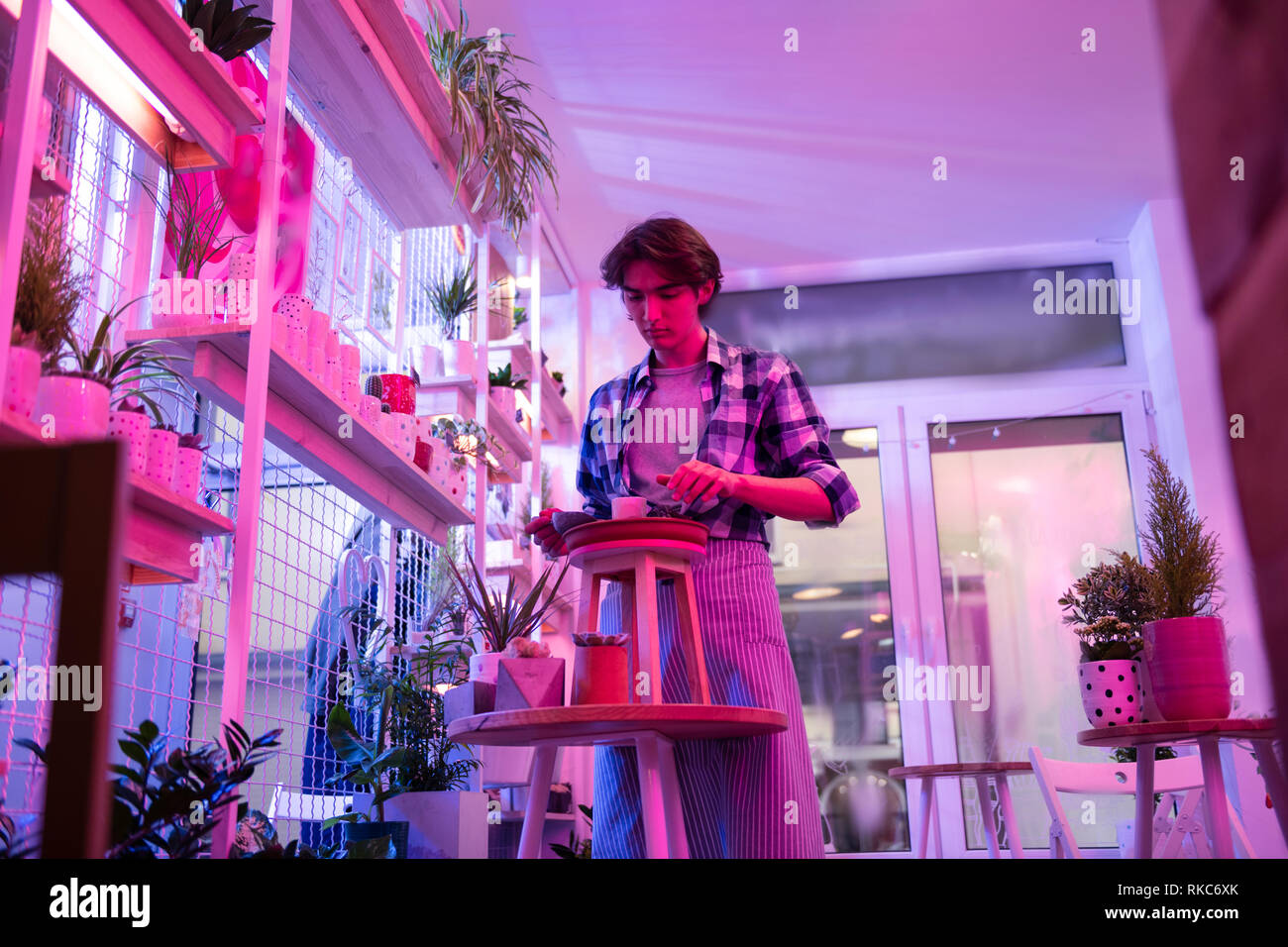 Handsome dark-haired worker being interested in garden works Stock Photo