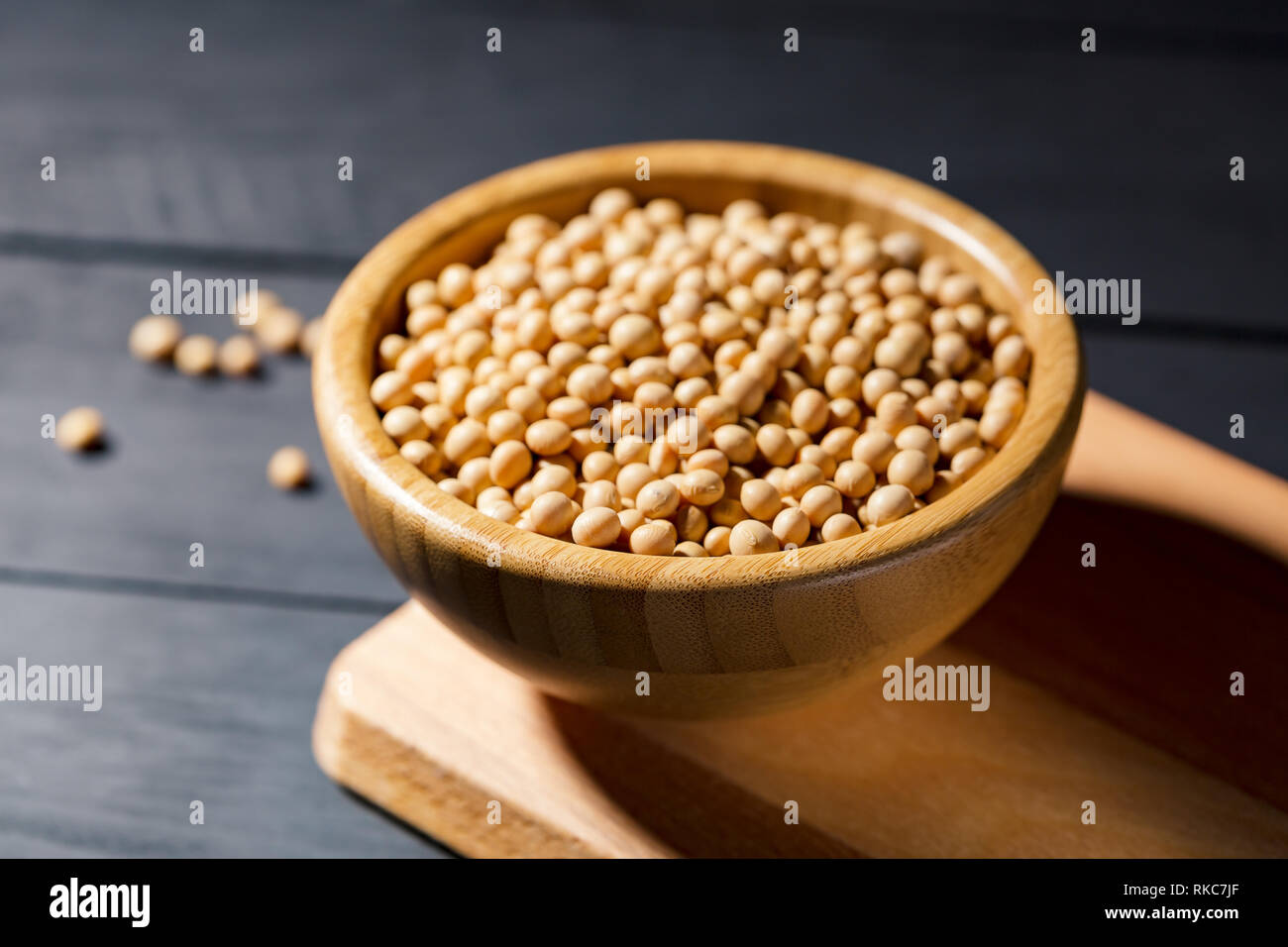 Soybeans in wooden bowl on darck background, soft focus. Vegan protein