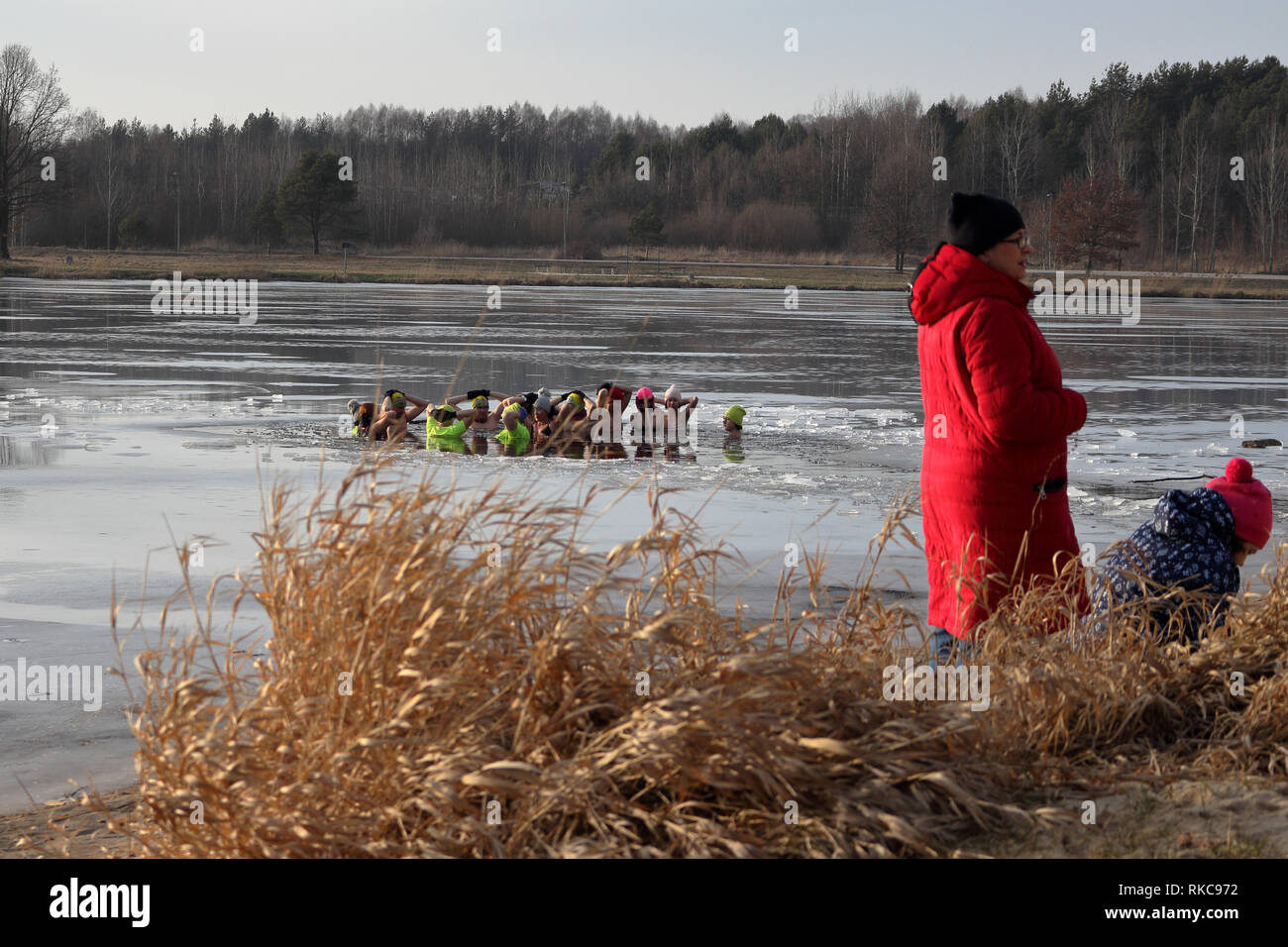 Umer, Poland. 10th Feb 2019.  A group of people winter bath in ice covered lake while observers dressed in warm clothes watch the event Credit: Slawomir Wojcik/Alamy Live News Stock Photo