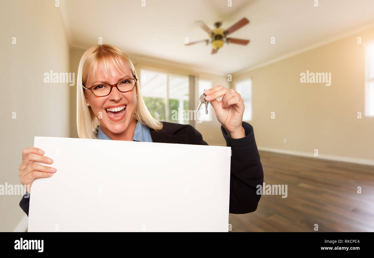 Attractive Young Woman with New Keys and Blank Board In Empty Room of ...