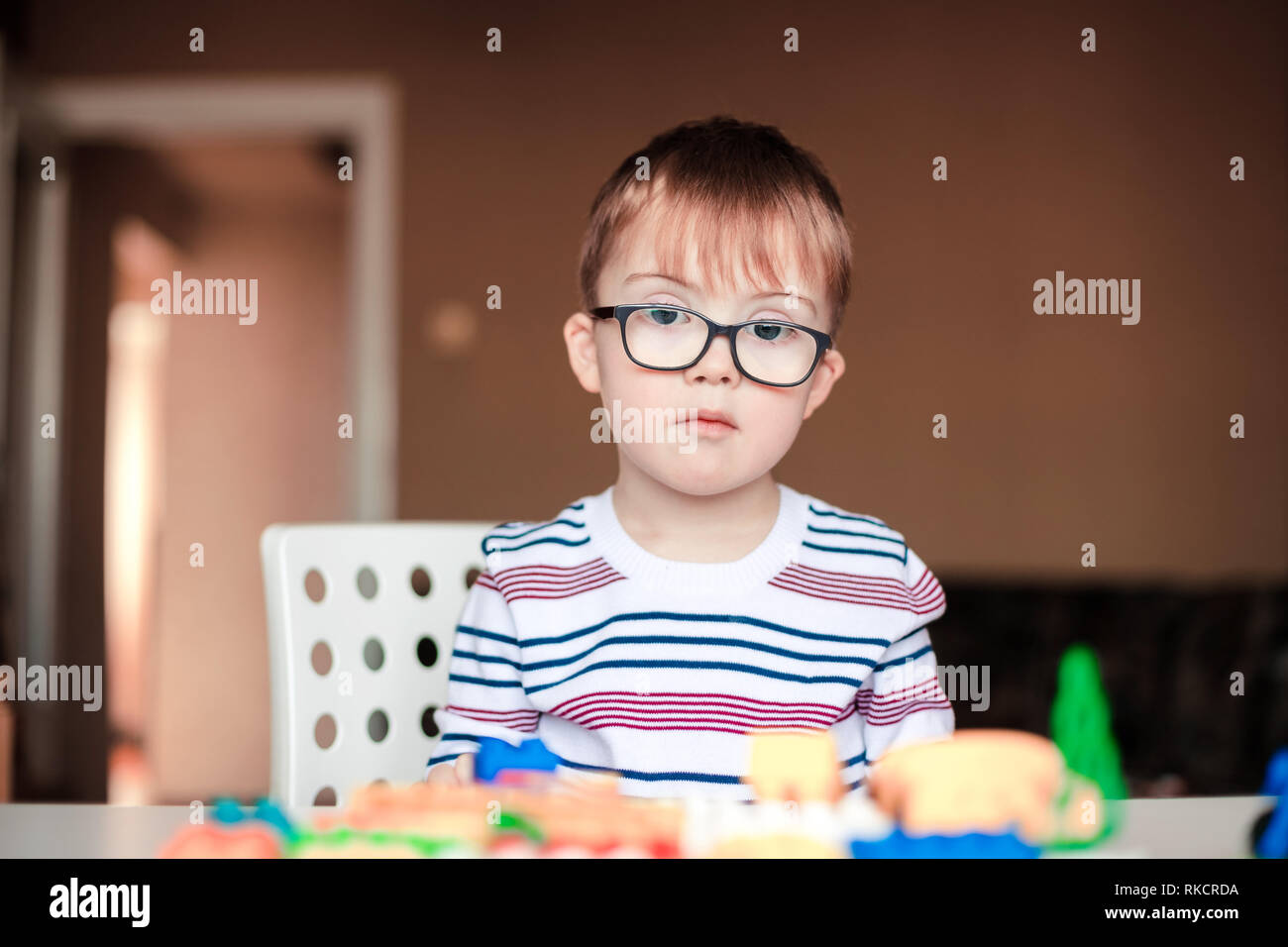 little boy with syndrome dawn playing with lego Stock Photo