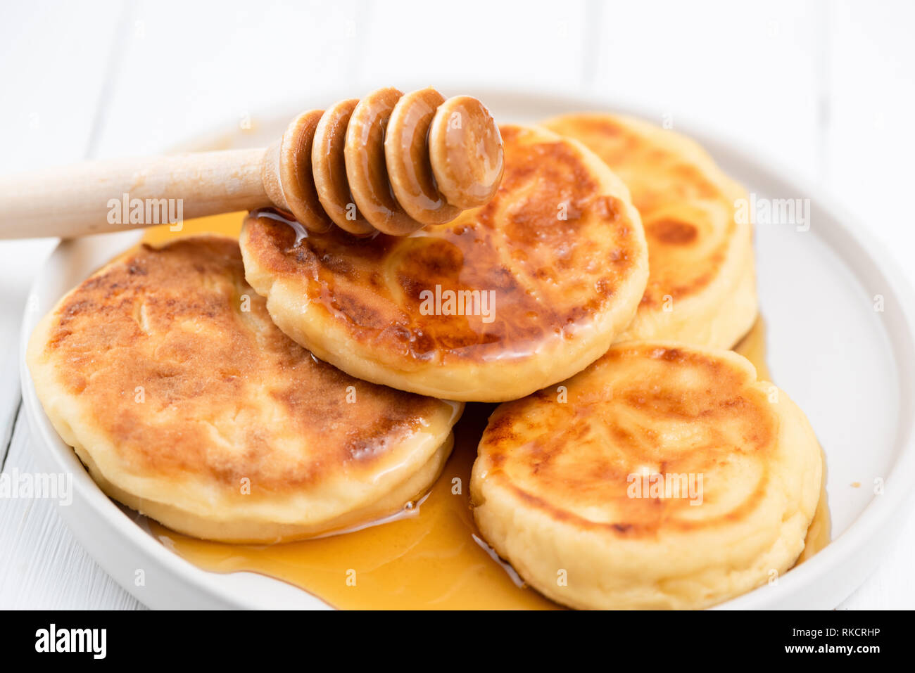 Syrniki, cottage cheese pancakes with honey. Tasty breakfast food. Rich in Calcium cheese pancakes Stock Photo