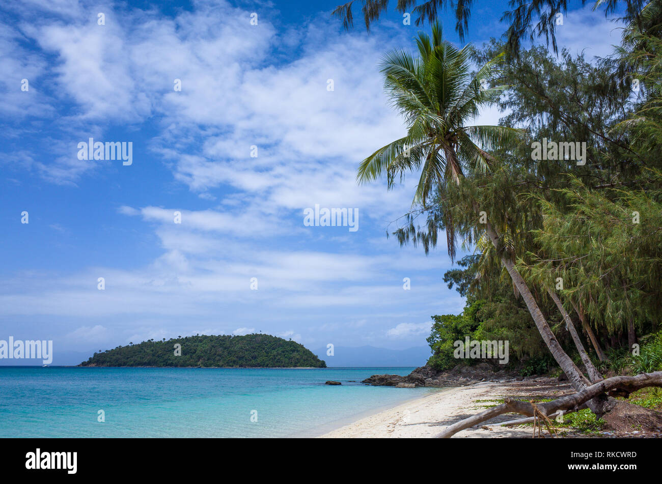 Perfect tiny island in turquoise sea, with palm trees and rugged Bonbon Beach, Romblon - Philippines Stock Photo