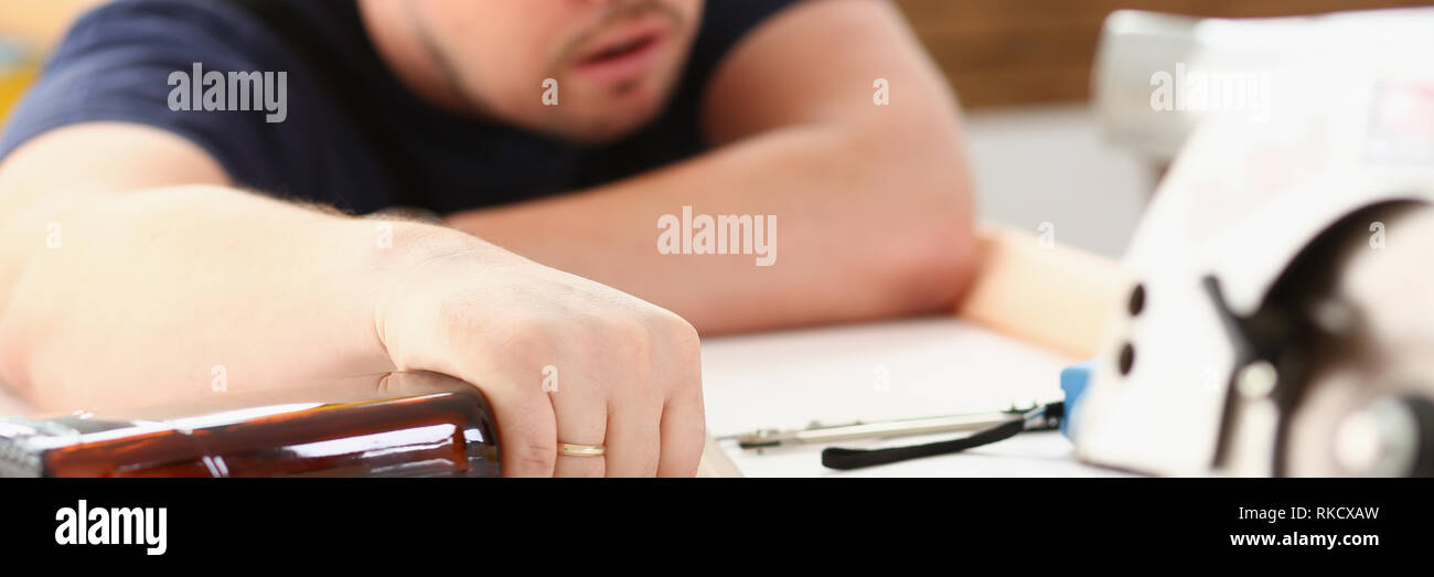 Arm of drunken worker in yellow helmet Stock Photo