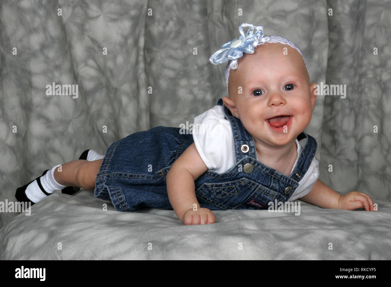 A baby girl poses for the camera with a big smile. Stock Photo