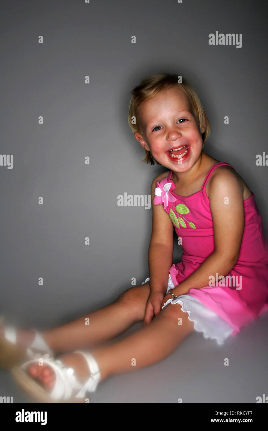 A baby girl poses for the camera with a big smile. Stock Photo