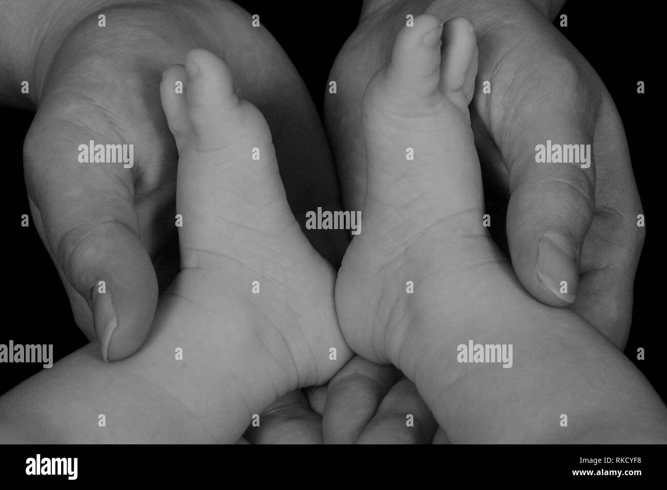 A mother’s hands hold her babies feet Stock Photo Alamy