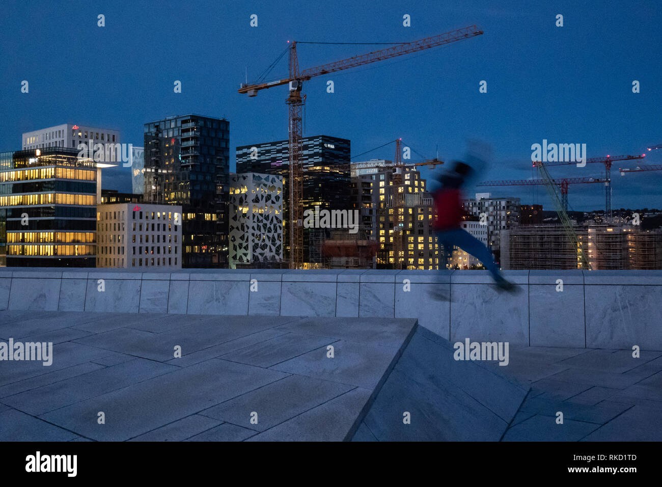 Kid jumping off the roof at the Norwegian Opera House in Oslo at night Stock Photo