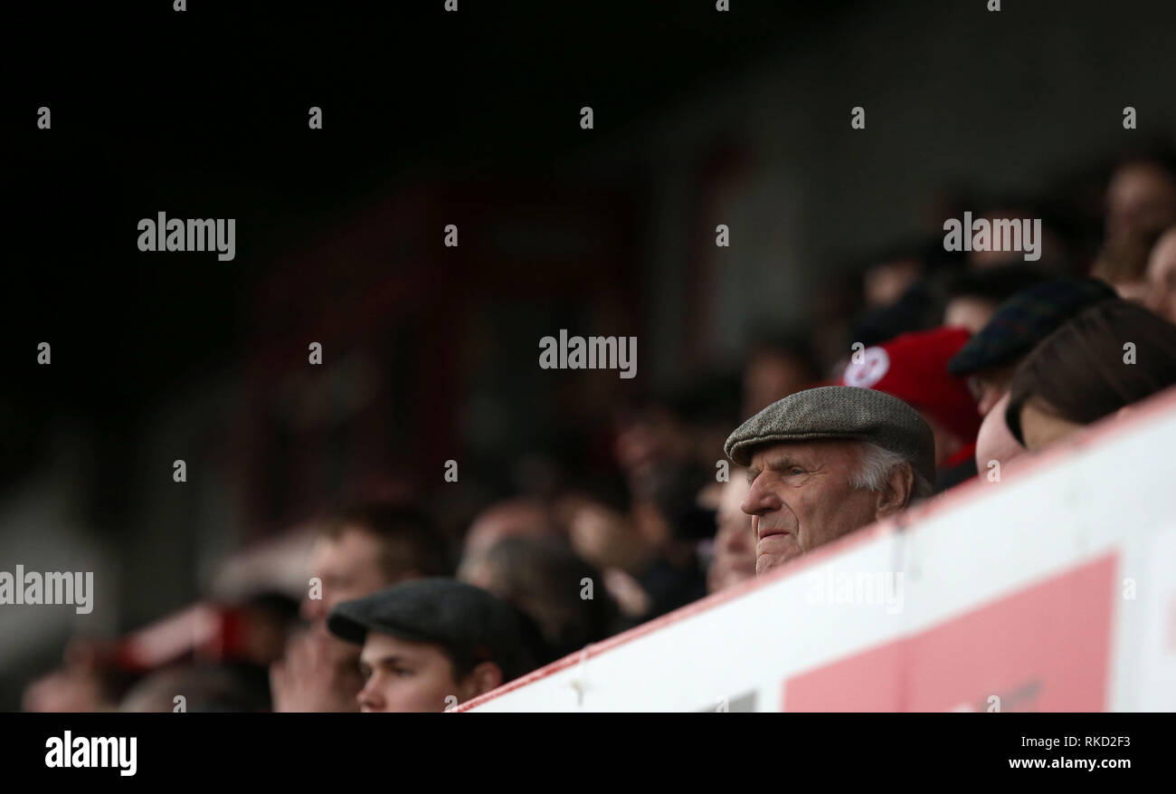 A man in a flat cap watches a football match in England, UK. Editorial use only. No merchandising. For Football images FA and Premier League restrictions apply inc. no internet/mobile usage without FAPL license - for details contact Football Dataco Stock Photo