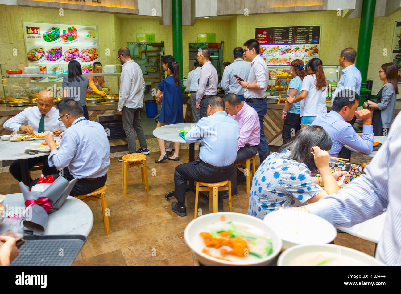 SINGAPORE - JAN 16, 2017 : People at popular food court in Singapore. Inexpensive food stalls are numerous in the city so most Singaporeans dine out a Stock Photo