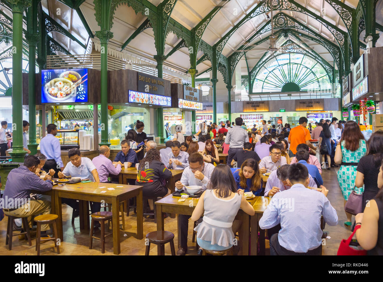 SINGAPORE - JAN 16, 2017 : People at popular food court in Singapore. Inexpensive food stalls are numerous in the city so most Singaporeans dine out a Stock Photo
