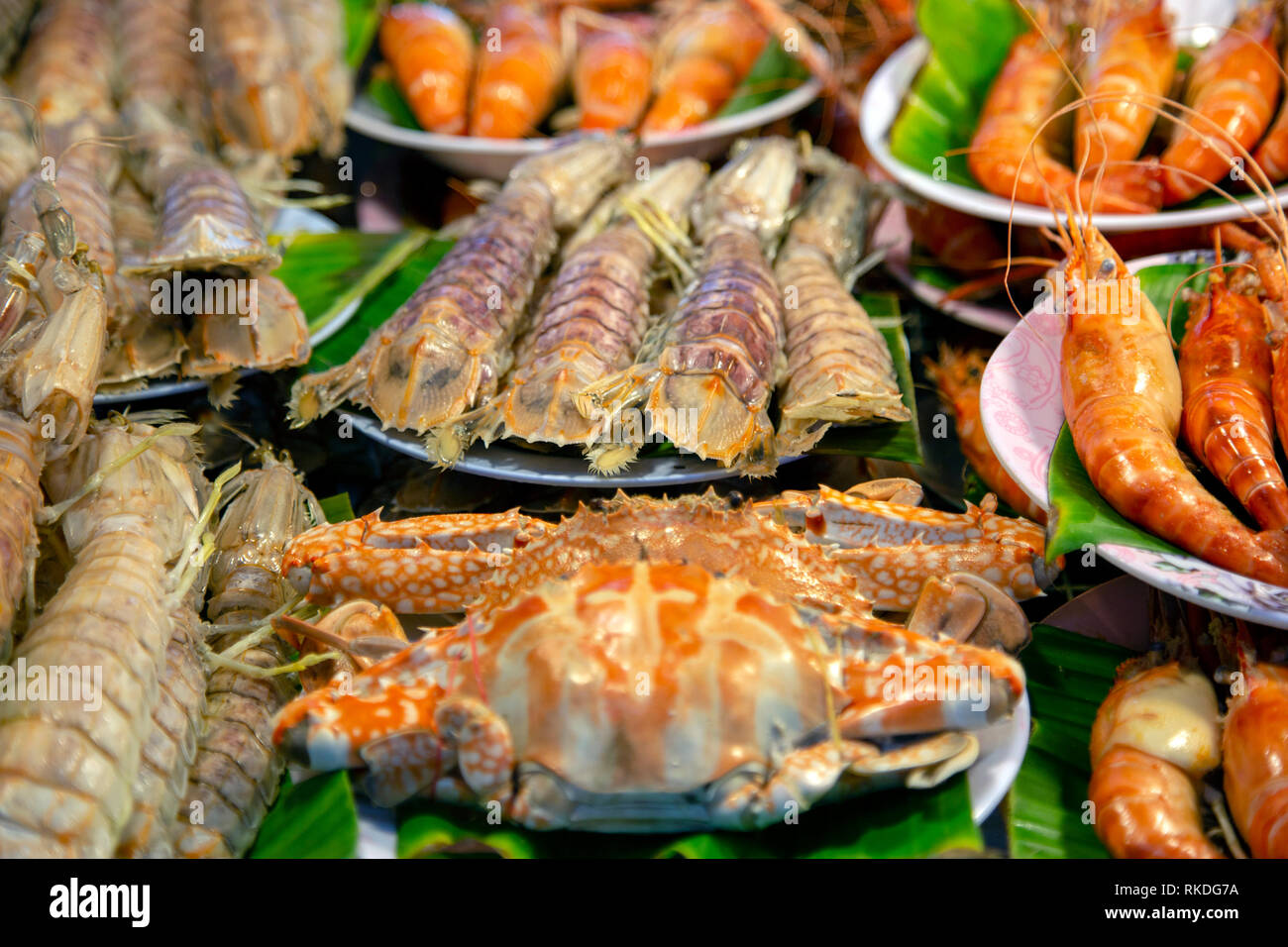 An arrangement of  cooked crab, shrimp, prawn, mantis prawn shellfish crustacean seafood at a fish market food stall in Phuket, Thailand. Stock Photo
