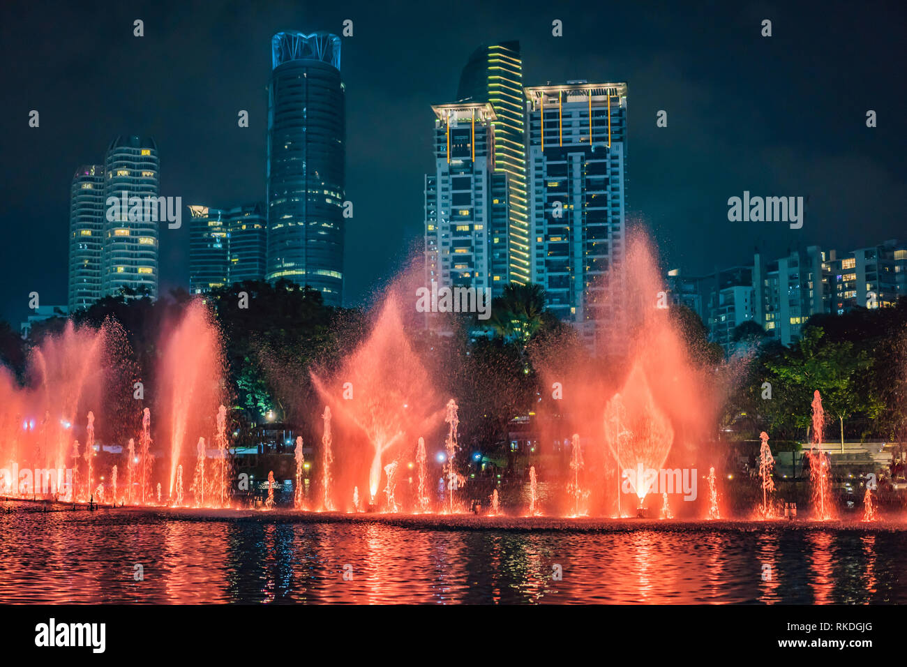 The colorful fountain on the lake at night, near by Twin Towers with ...