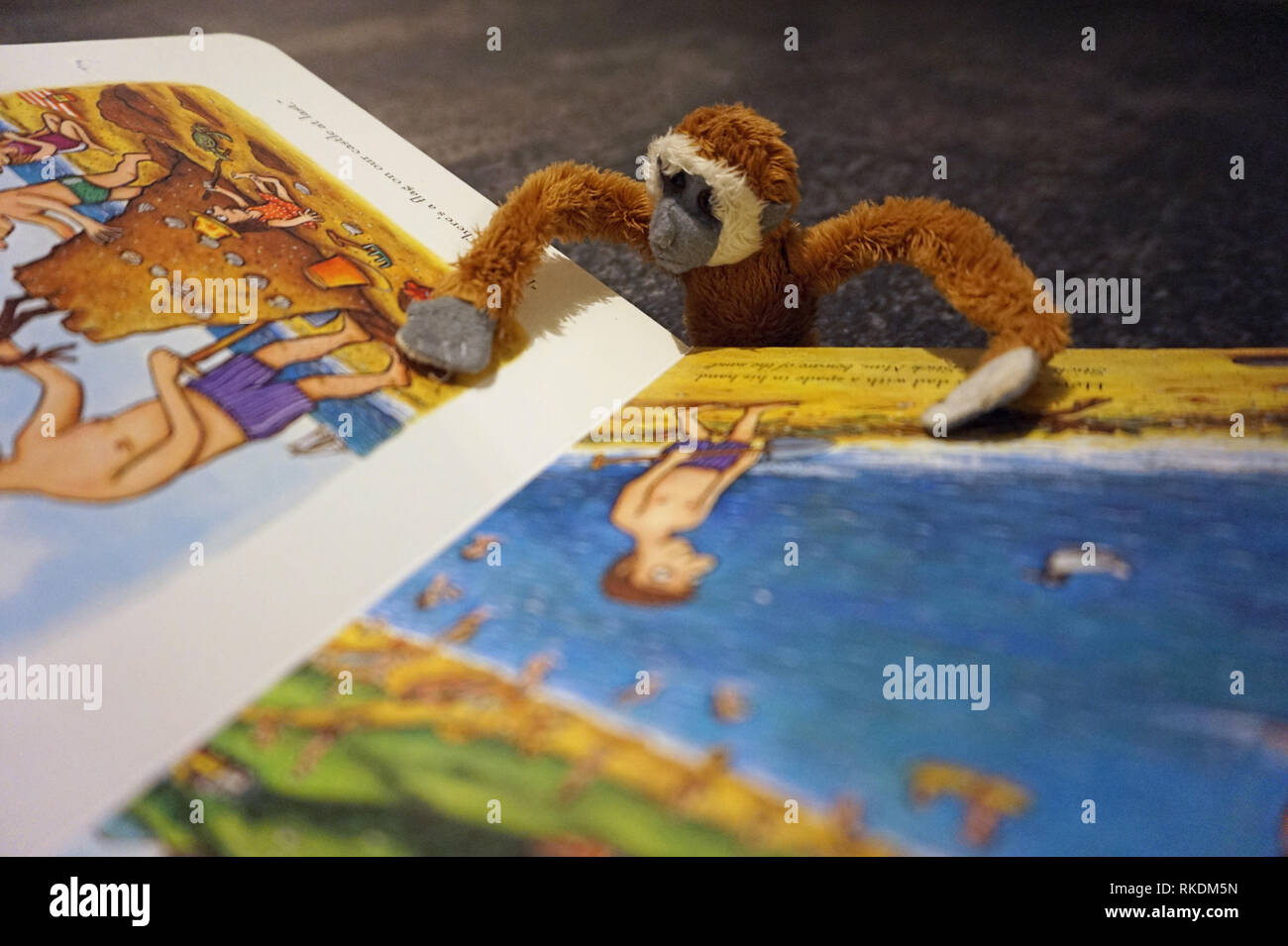 Toy soft monkey reading a children's book Stock Photo