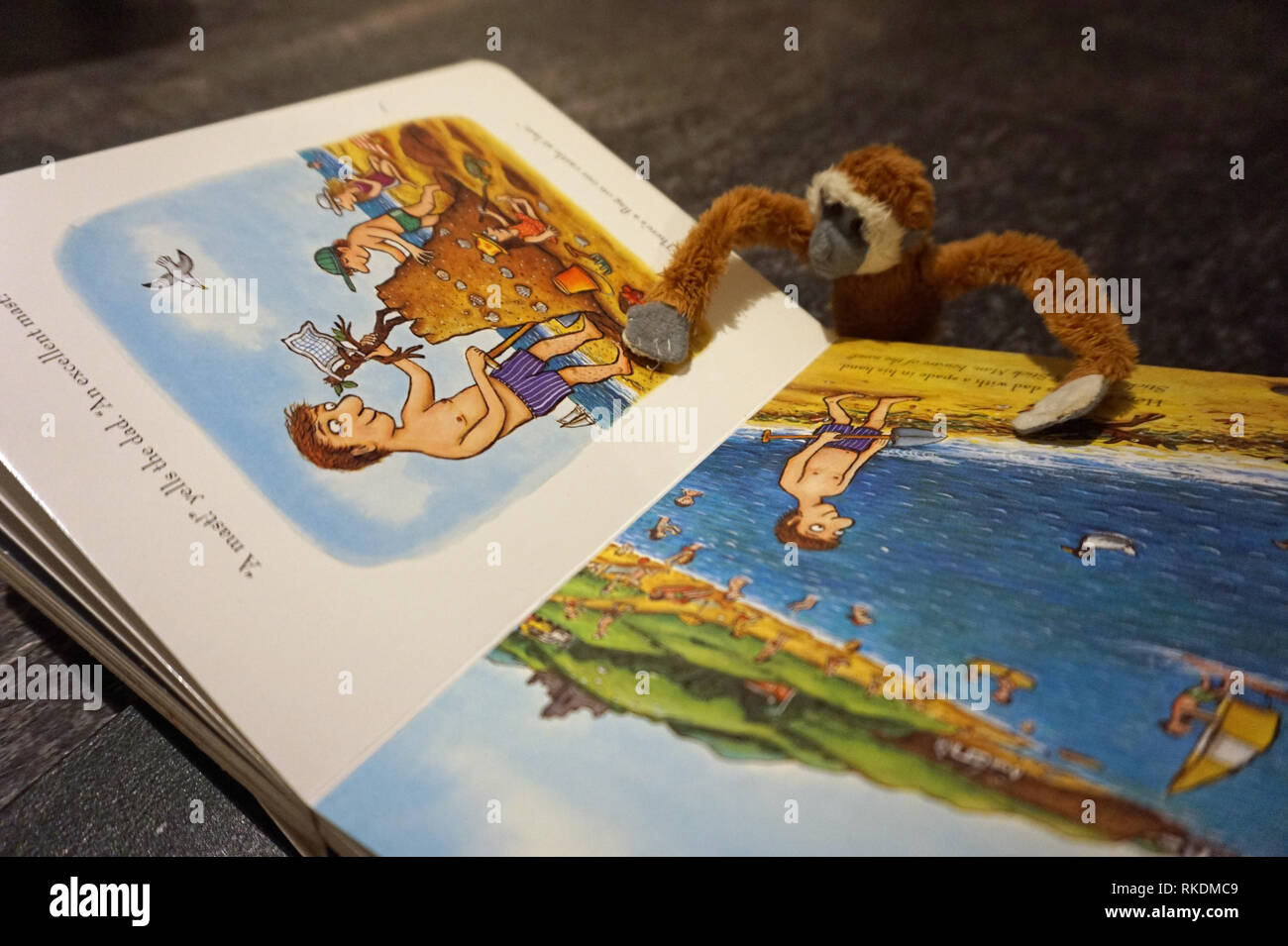 Toy soft monkey reading a children's book Stock Photo