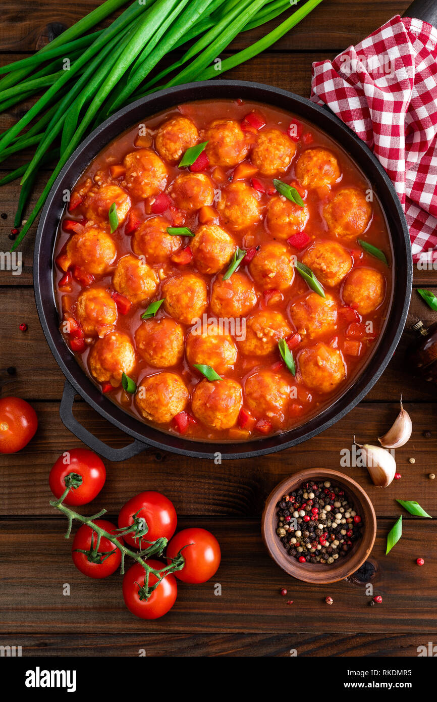 Chicken meatballs in spicy tomato sauce with vegetables in pan. Mexican
