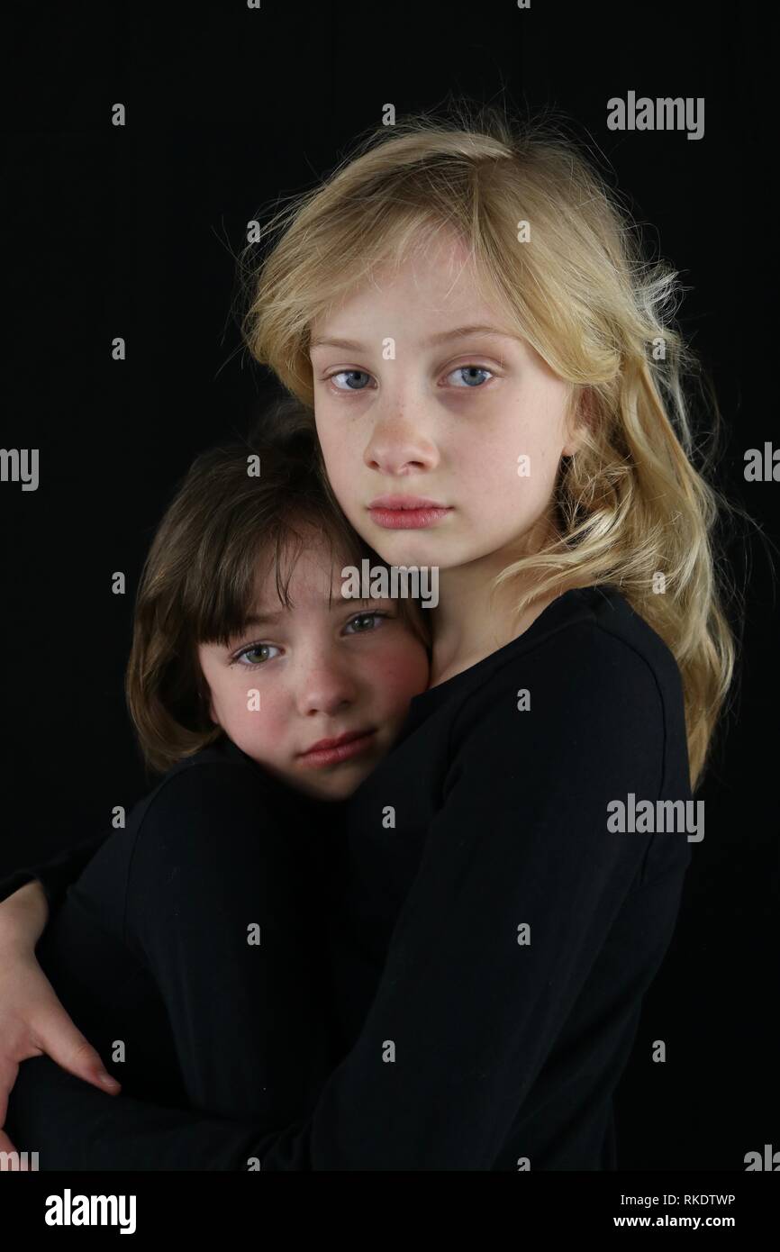 Grieving children holding onto each other Stock Photo
