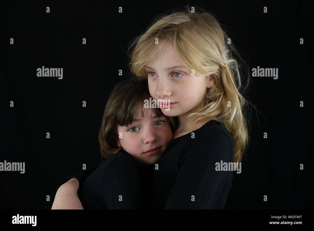 Two girls in an embrace missing a loved one Stock Photo