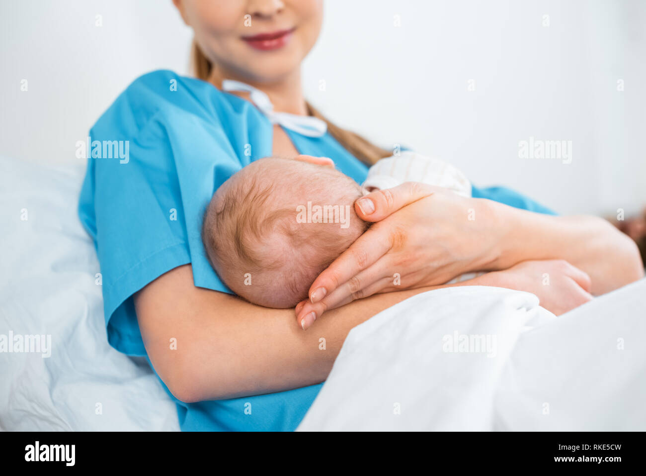 low angle view of smiling young mother breastfeeding newborn baby on