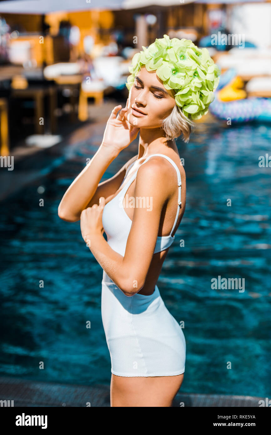 beautiful pin up girl posing in white swimsuit at poolside Stock Photo -  Alamy