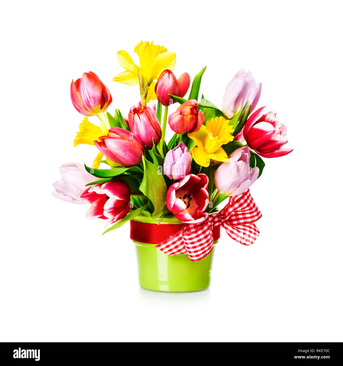 Tulips and daffodils in green vase with bow. Spring flowers bouquet ...