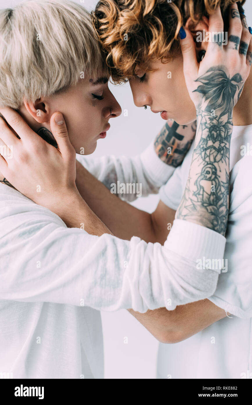 Girlfriend With Tattoos Embracing Boyfriend With Curly Hair Isolated On Grey Stock Photo Alamy