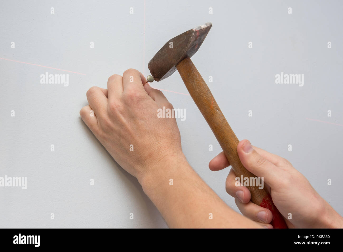 Male hand hammering a nail into the wall Stock Photo Alamy