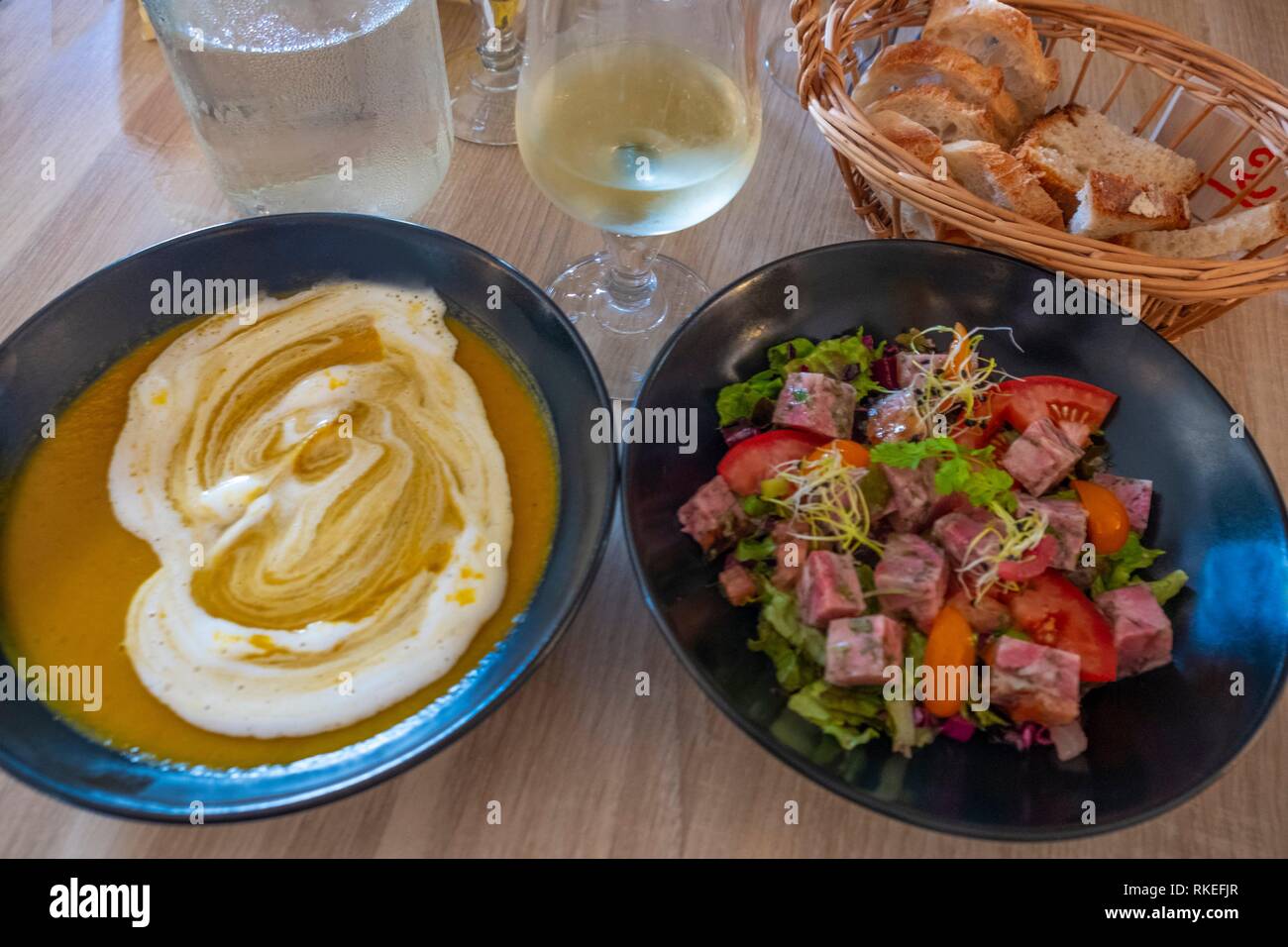 France. Food. Entrées: ''Soupe de legume a la créme fraiche'', and ''Salade de Museau de porc''. Stock Photo