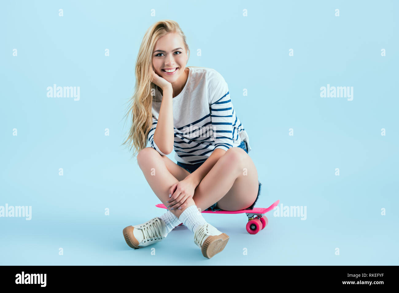 Smiling blonde girl sitting crossed hi-res stock photography and images ...