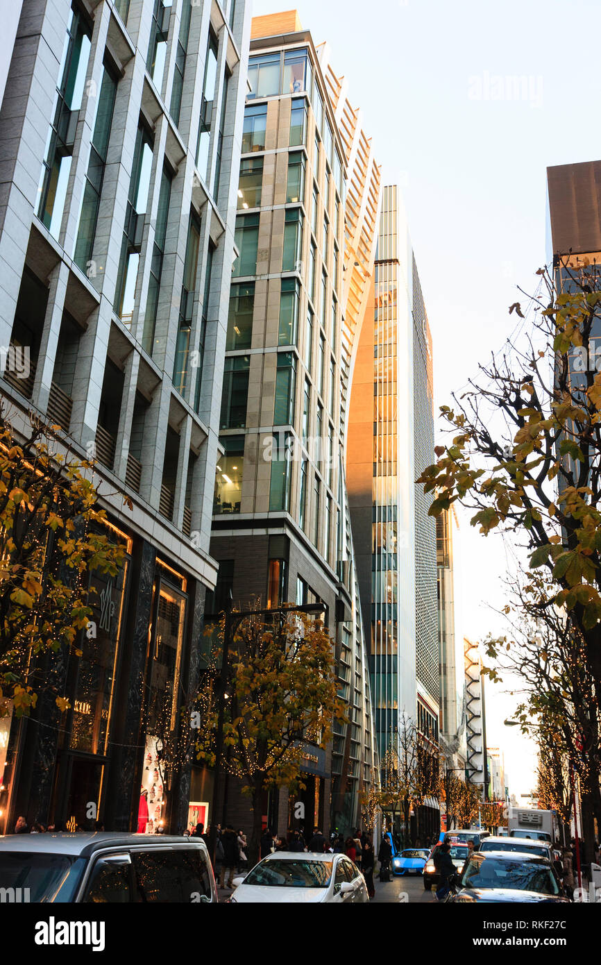 Tokyo, Ginza, golden hour. The undulating stainless-steel facade of the V88 building, formerly De Beers Ginza, poking out between other buildings. Stock Photo