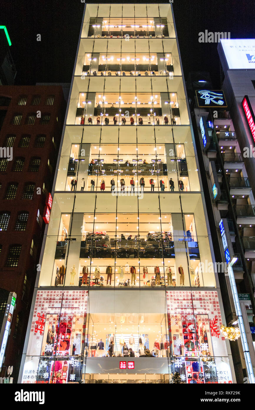 Tokyo Ginza, night. Across street view of Flagship glass facade Uniqlo 12  story store illuminated. Taxi in foreground. Christmas trees on pavement  Stock Photo - Alamy