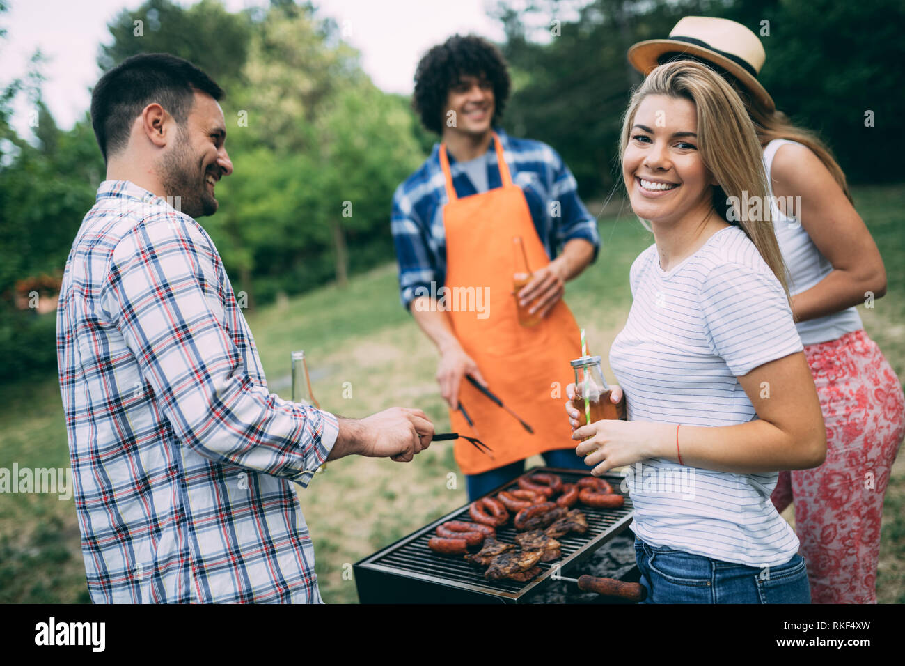 Group of happy friends having a barbecue party in nature Stock Photo ...