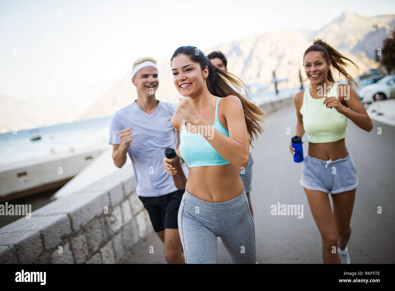 Outdoor portrait of group of friends running and jogging in nature ...