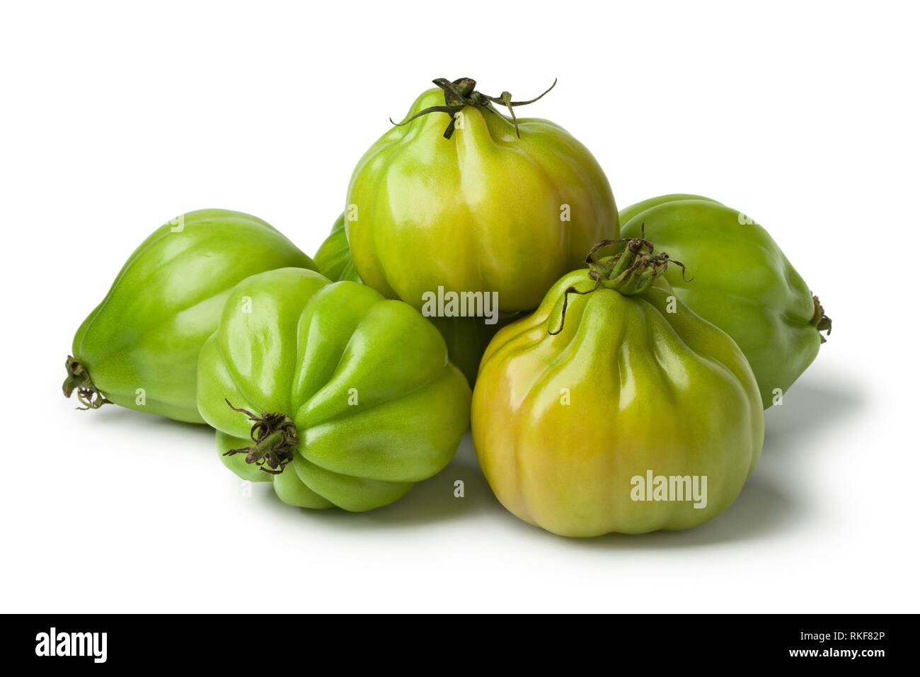 Heap of green Coeur de boeuf tomatoes on white background. Stock Photo