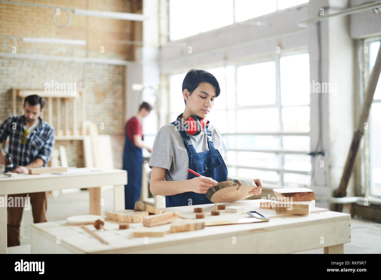 Masculine girl drawing on slice of wood Stock Photo