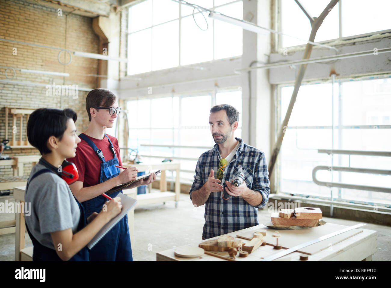 Teaching carpentry students in workshop Stock Photo