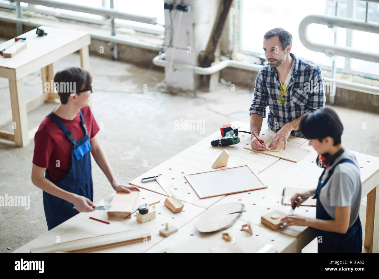 Carpenters chatting while working with wood Stock Photo