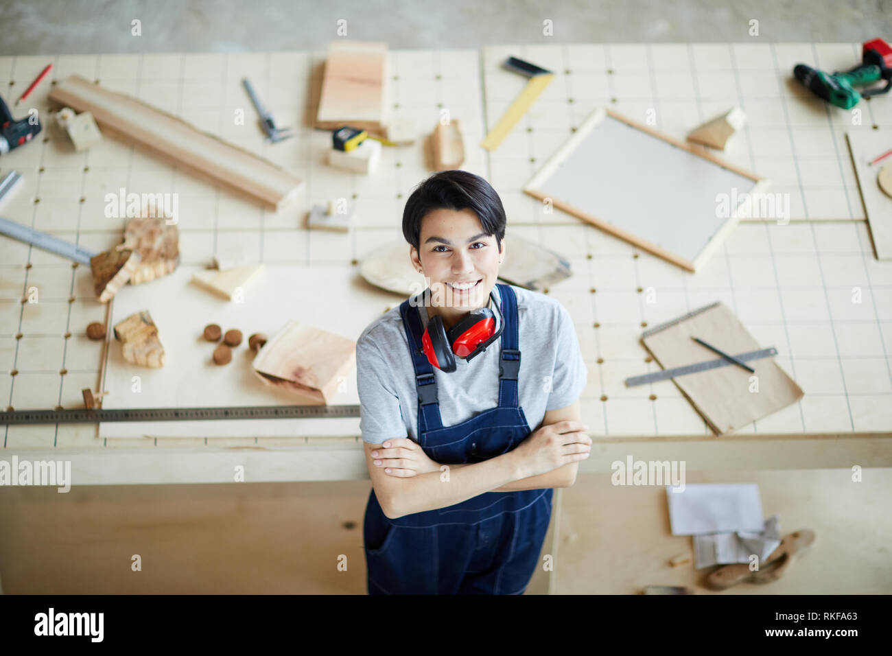 Cheerful lady carpenter in own workshop Stock Photo