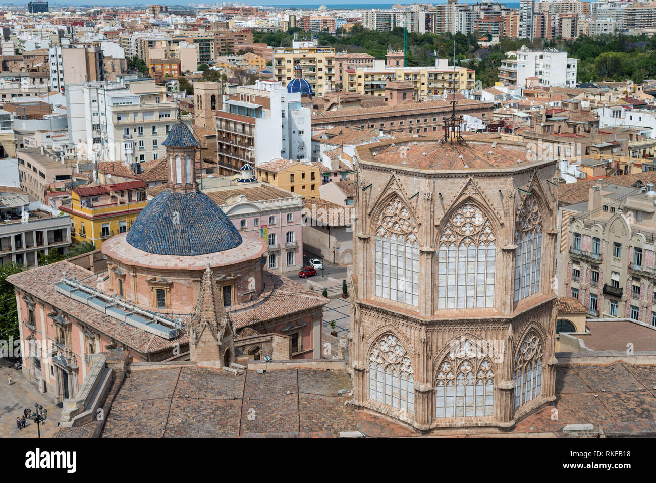 An aerial view of the historic old town of Valencia, Spain, with the Micalet Bell Tower of Valencia Cathedral prominently rising above tiled rooftops.