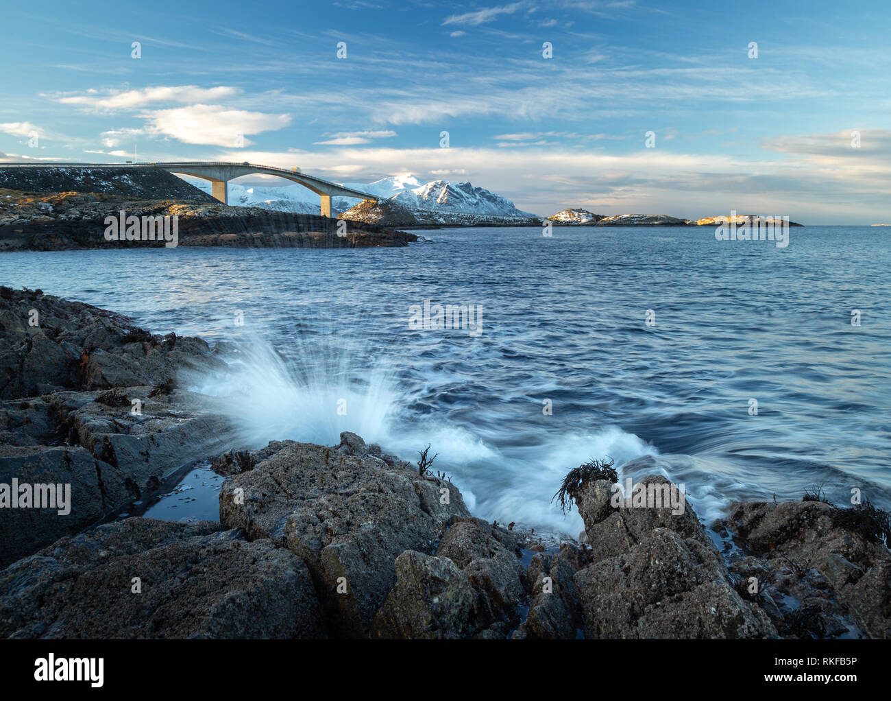 Rocky coast by the Atlantic Ocean Road in Norway. Long exposure shots. View on the famous bridge Storseisundbrua and breaking waves. Stock Photo