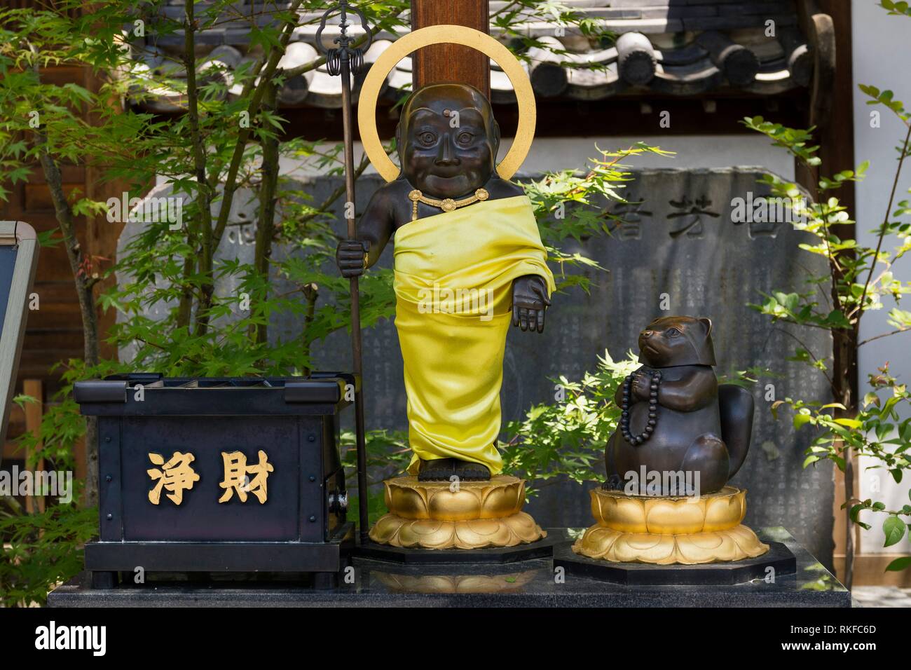 Statue of the monk and Mujina, a devoted raccoon dog, at the Buddhist Zenkoji temple according to the legend. Stock Photo