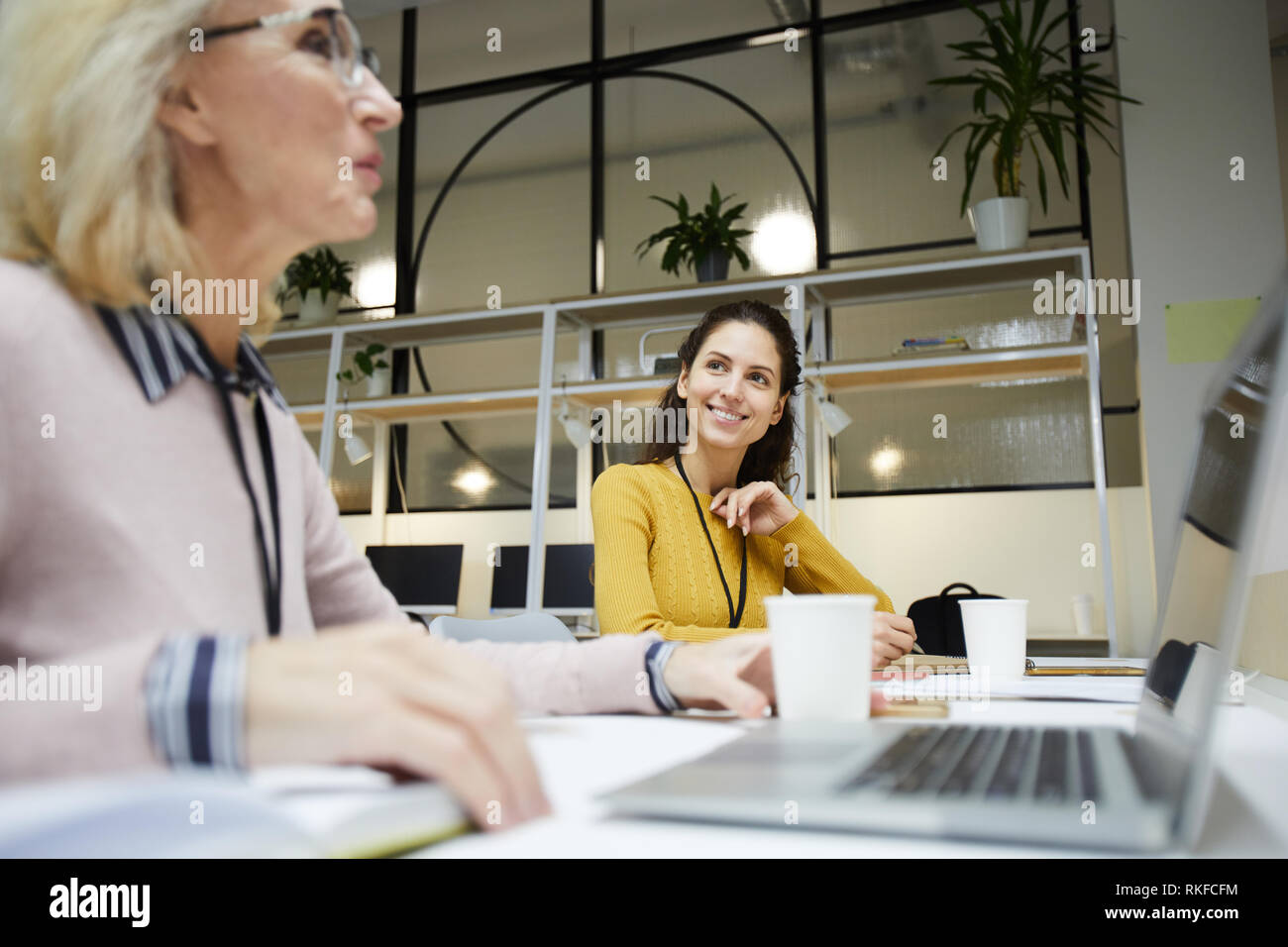 Smiling ladies chatting in office Stock Photo
