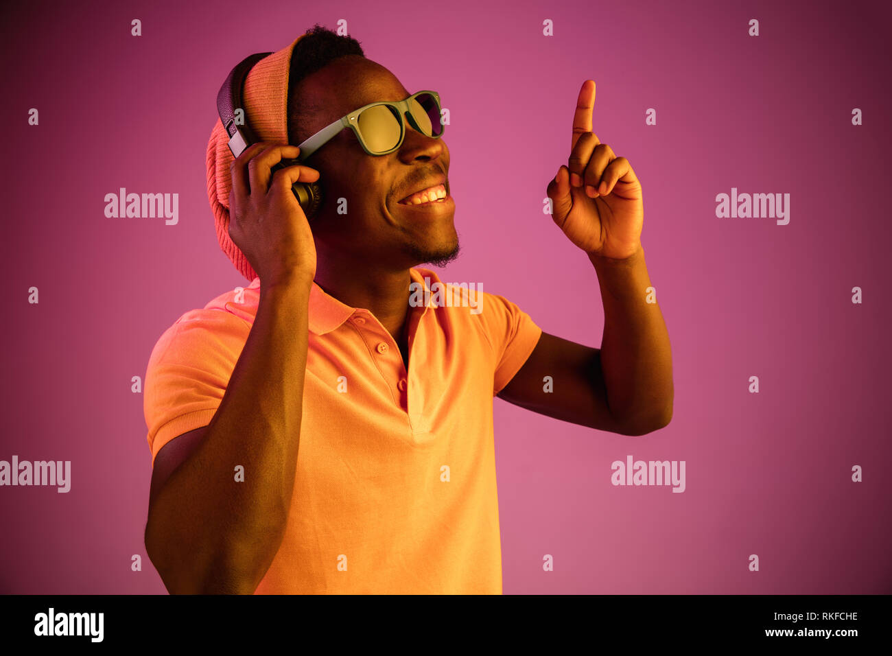 The young handsome happy hipster man listening music with headphones at