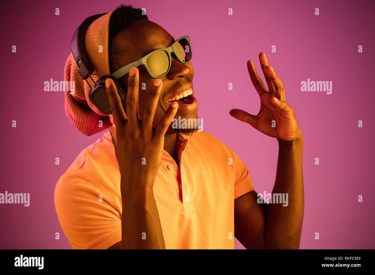 The young handsome happy hipster man listening music with headphones at