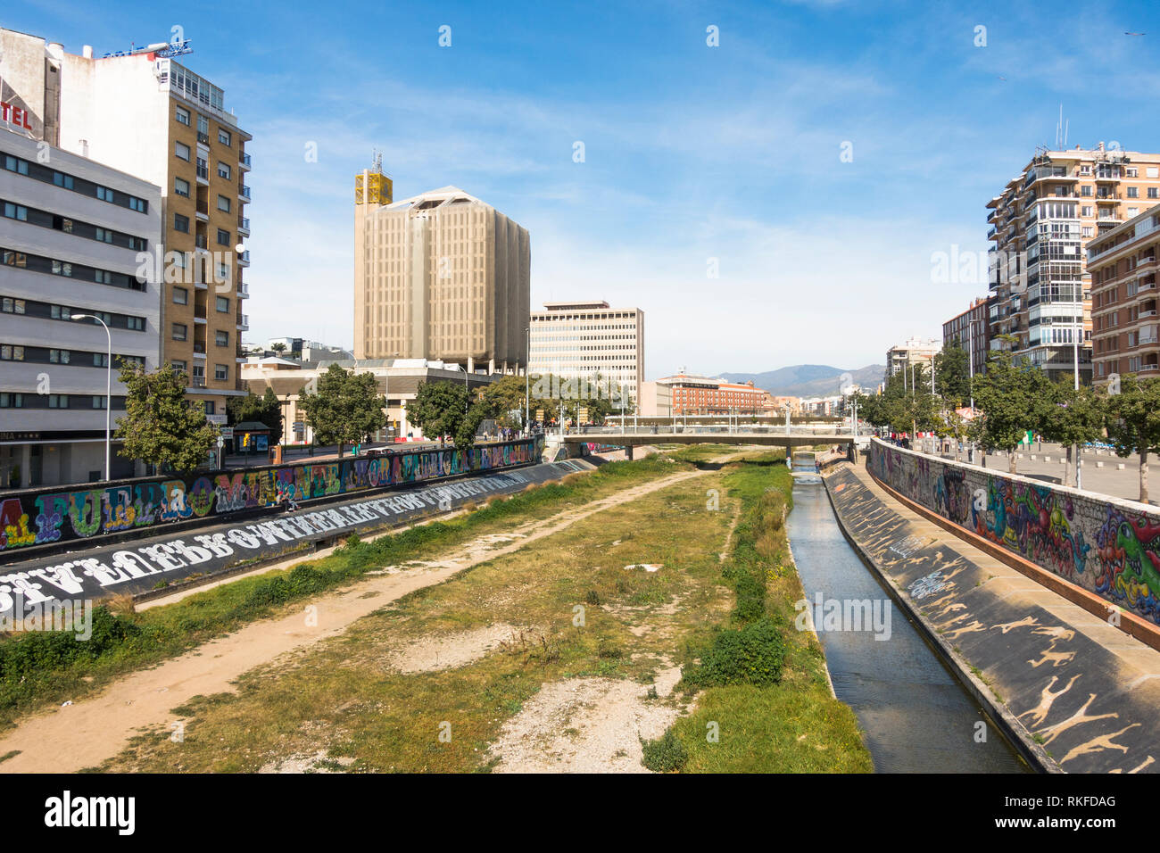 Malaga Spain. Guadalmedina river of Malaga City with former post office Correos Building left, Málaga, Spain. Stock Photo