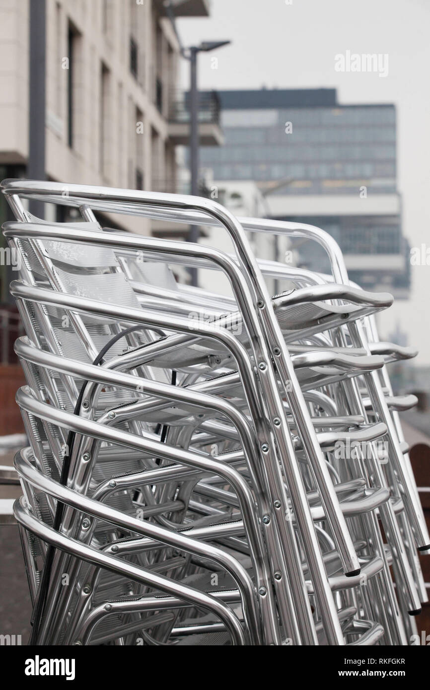 stacked aluminium garden chairs in the Rheinau harbor, Cologne, Germany.  gestapelte Aluminium-Gartenstuehle im Rheinauhafen, Koeln, Deutschland. Stock Photo